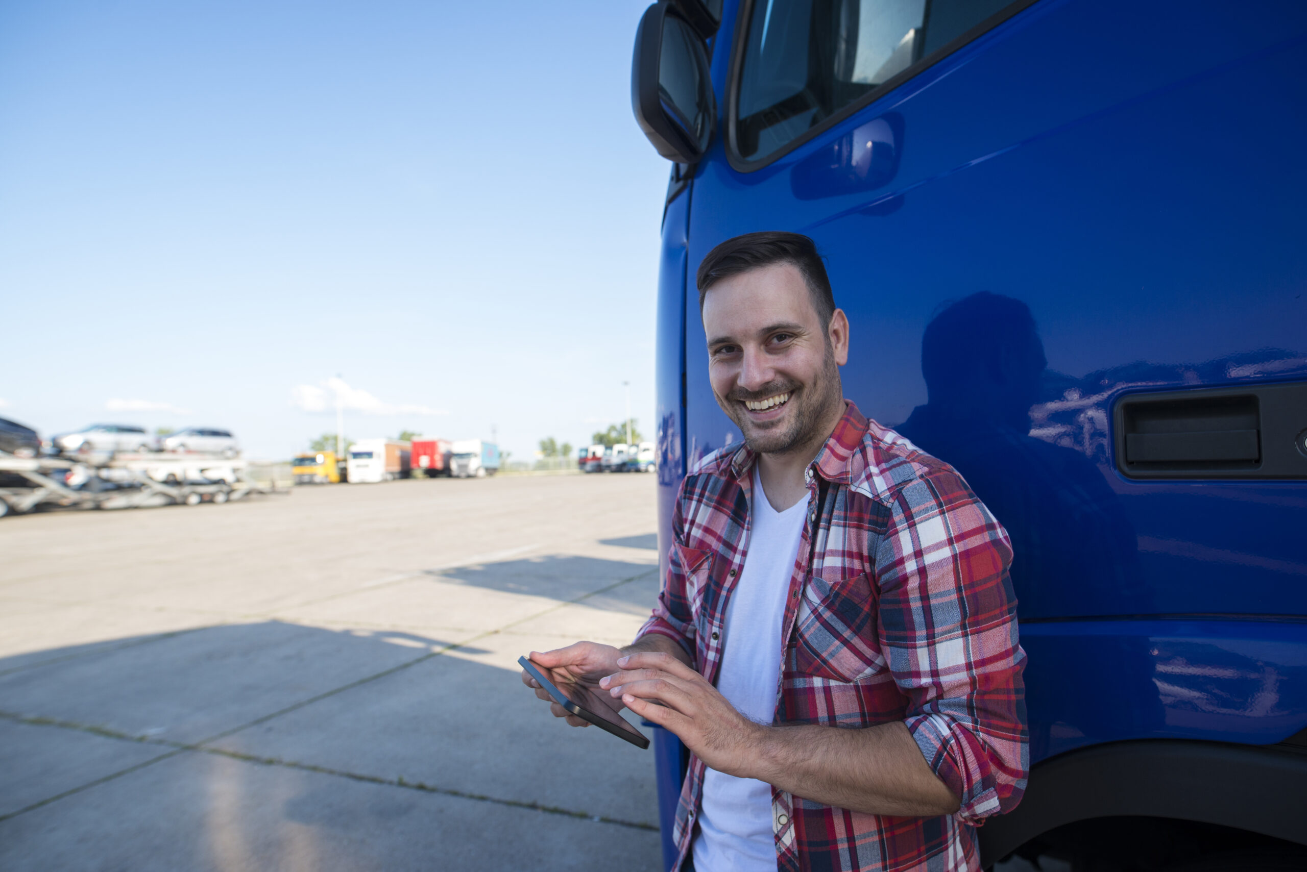 Motorista configurando GPS ao lado do caminhão